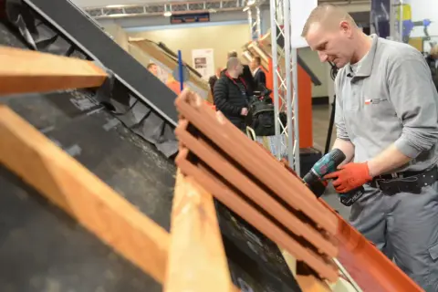 Dekarz na Dolnym Śląsku zarabia dobrze, co widać po jego zaangażowaniu w pracę z dachówką i narzędziami.
